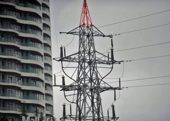 This picture shows an electrical pylon standing beside a building in Istanbul on March 31, 2015, during a massive power outage.  A massive power cut caused chaos across Turkey, shutting down the metro networks in Istanbul and the capital Ankara, with the government saying an outside attack on the system was not ruled out.   AFP PHOTO/OZAN KOSE