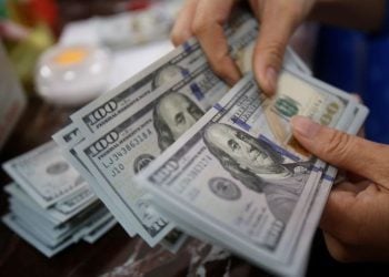 FILE PHOTO: An employee of a bank counts US dollar notes at a branch in Hanoi, Vietnam May 16, 2016. REUTERS/Kham/File Photo