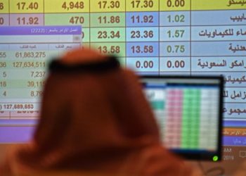 A Saudi broker watches stocks' fluctuation at the Arab National Bank in the Saudi capital Riyadh on December 11, 2019. - Saudi Aramco's shares soared on their debut on the domestic stock exchange Wednesday, becoming the world's biggest listed company worth $1.88 trillion after a record-breaking IPO. Aramco had priced the initial public offering at 32 riyals ($8.53) per share, raising $25.6 billion and eclipsing Alibaba's $25 billion IPO of 2014 to become the world's largest. (Photo by Fayez Nureldine / AFP)