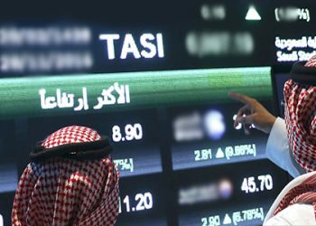 Visitors stand and watch stock movements displayed on large video screens inside the Saudi Stock Exchange, also known as the Tadawul All Share Index in Riyadh, Saudi Arabia, on Monday, Nov.28, 2016. The Tadawul All Share Index advanced 26 percent since Saudi Arabia’s record-breaking bond sale last month, the most in the world during that period. Photographer: Simon Dawson/Bloomberg