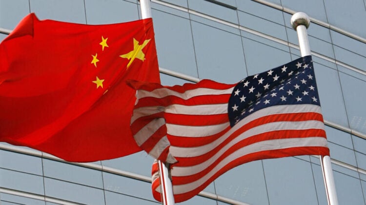 A US and a Chinese flag wave outside a commercial building in Beijing, 09 July 2007. US Secretary of State Condoleezza Rice 06 July 2007 accused China of flouting the rules of global trade in its headlong economic expansion as the US administration "has not been hesitant" to deploy trade tools against China, including a complaint lodged with the World Trade Organization over copyright piracy. AFP PHOTO/TEH ENG KOON (Photo by TEH ENG KOON / AFP)